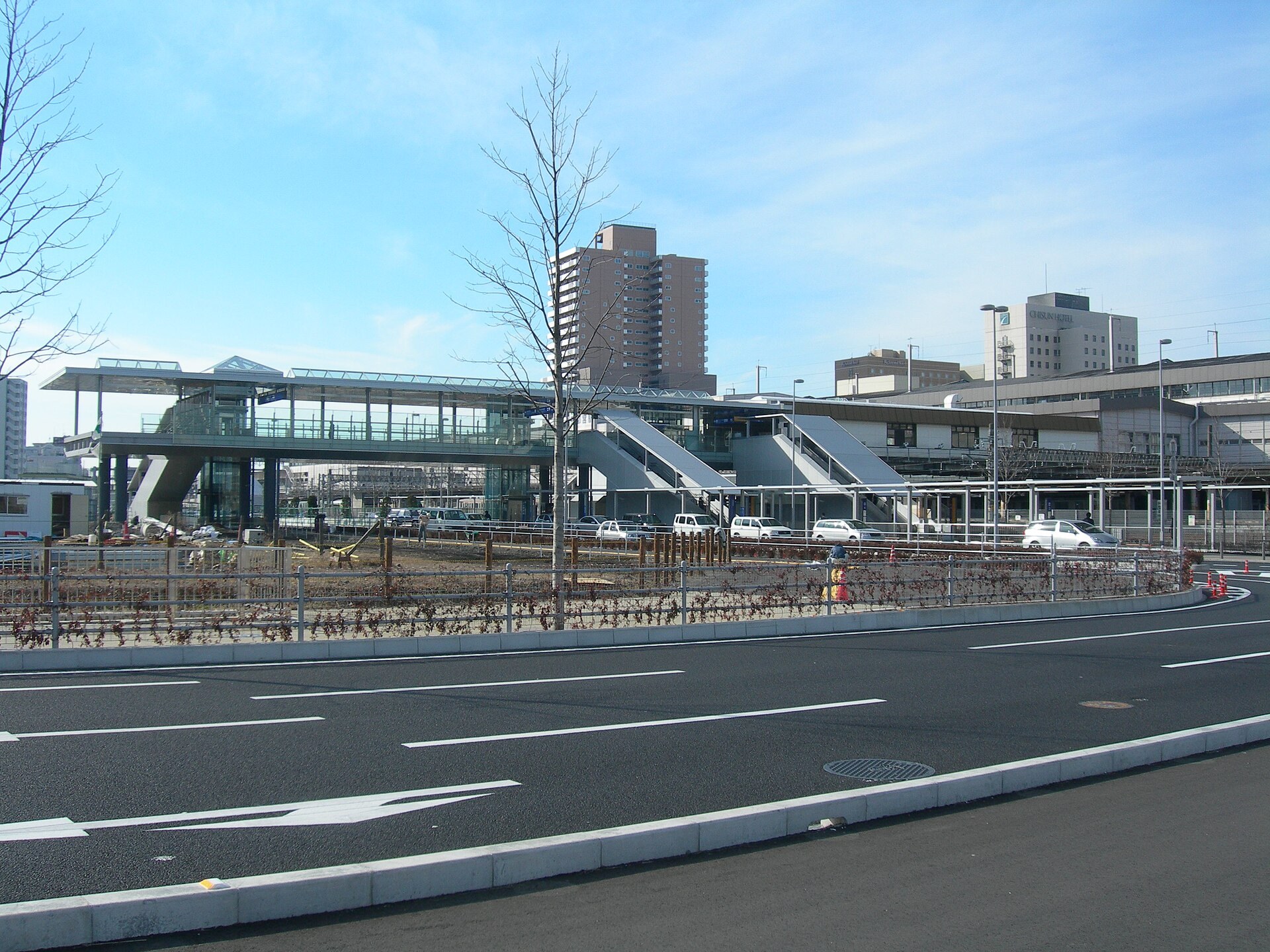 宇都宮輕軌列車停靠於低地台月台，背景為都市街景