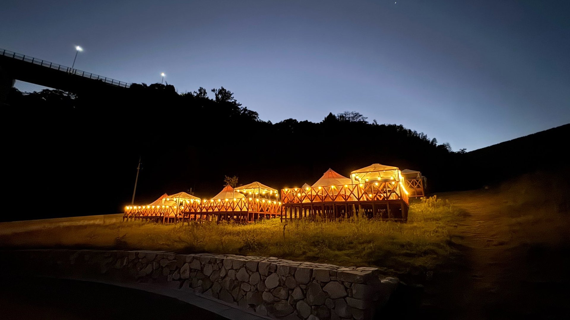 夜晚喺草地營地亮燈嘅露營帳篷