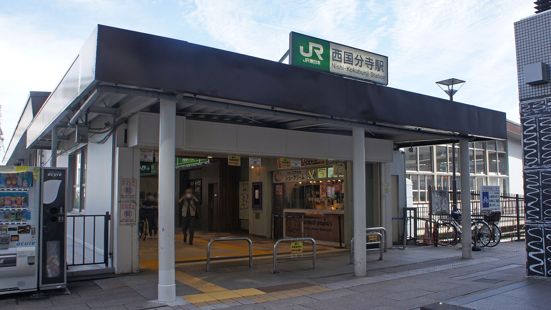 國分寺街頭藝術表演，觀眾沿路觀看在路邊嘅site-specific表演，背景為日本郊區街道