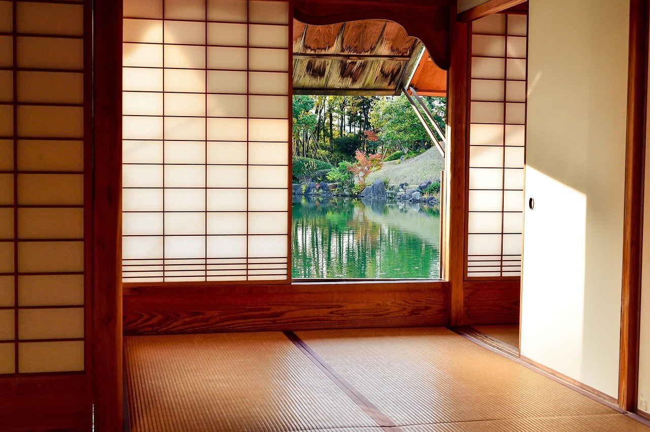 東京椿山荘茶室「殘月」內，榻榻米地台上有茶碗擺放，窗外可見庭園