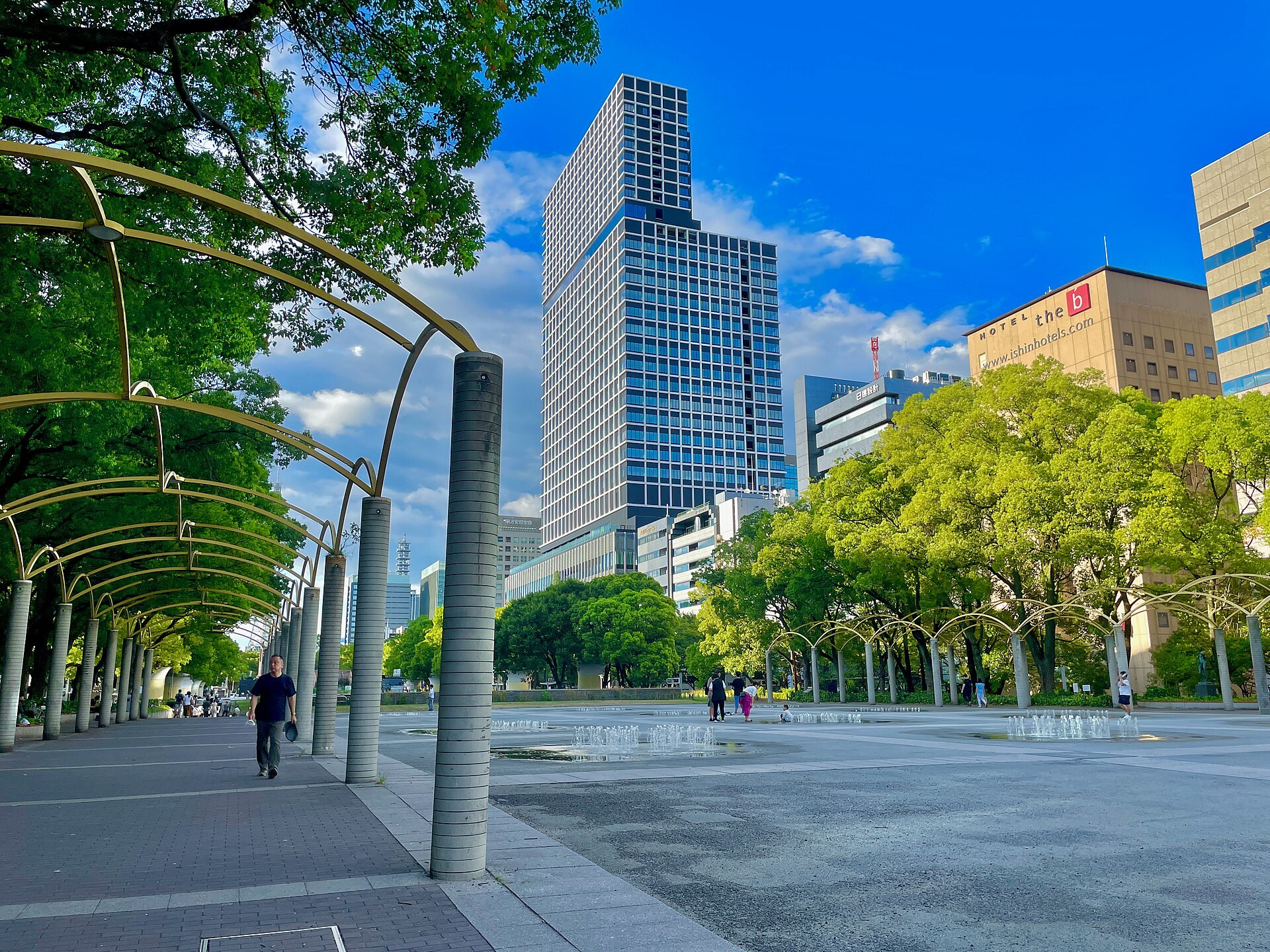 名古屋 Hisaya-odori Park 公園廣場,一排咖啡小攤檔擺開,行人慢慢行,背景係欅樹同開放嘅草地