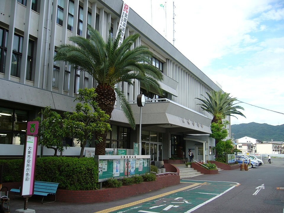 日本地方祭典中彩色塗裝嘅傳統木製地車(だんじり)隊伍喺街道上行進嘅寫實場景,無人出鏡或僅遠處人群背影。
