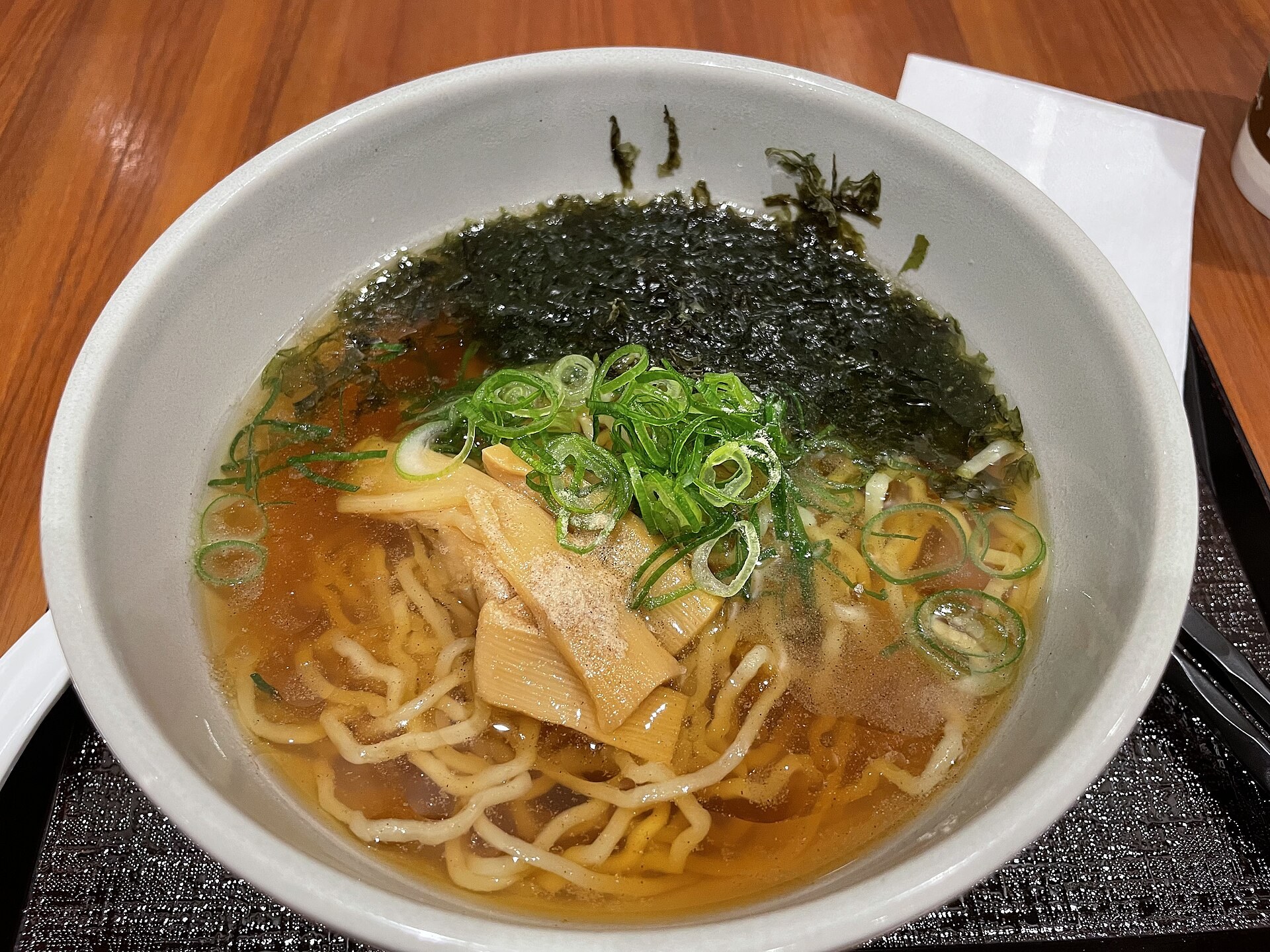 日式酒店房間內，桌上有一碗味噌湯底嘅麵，背景有榻榻米