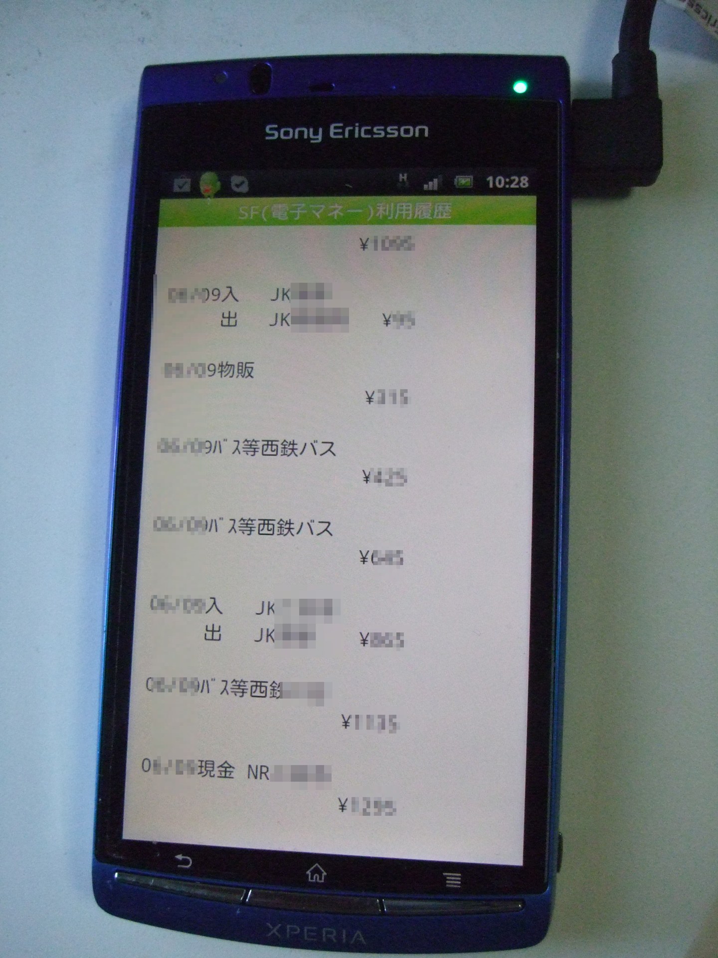 一雙手持手機顯示付款 QR 碼,背景為日本車站月台,距離較遠、面部無清晰呈現