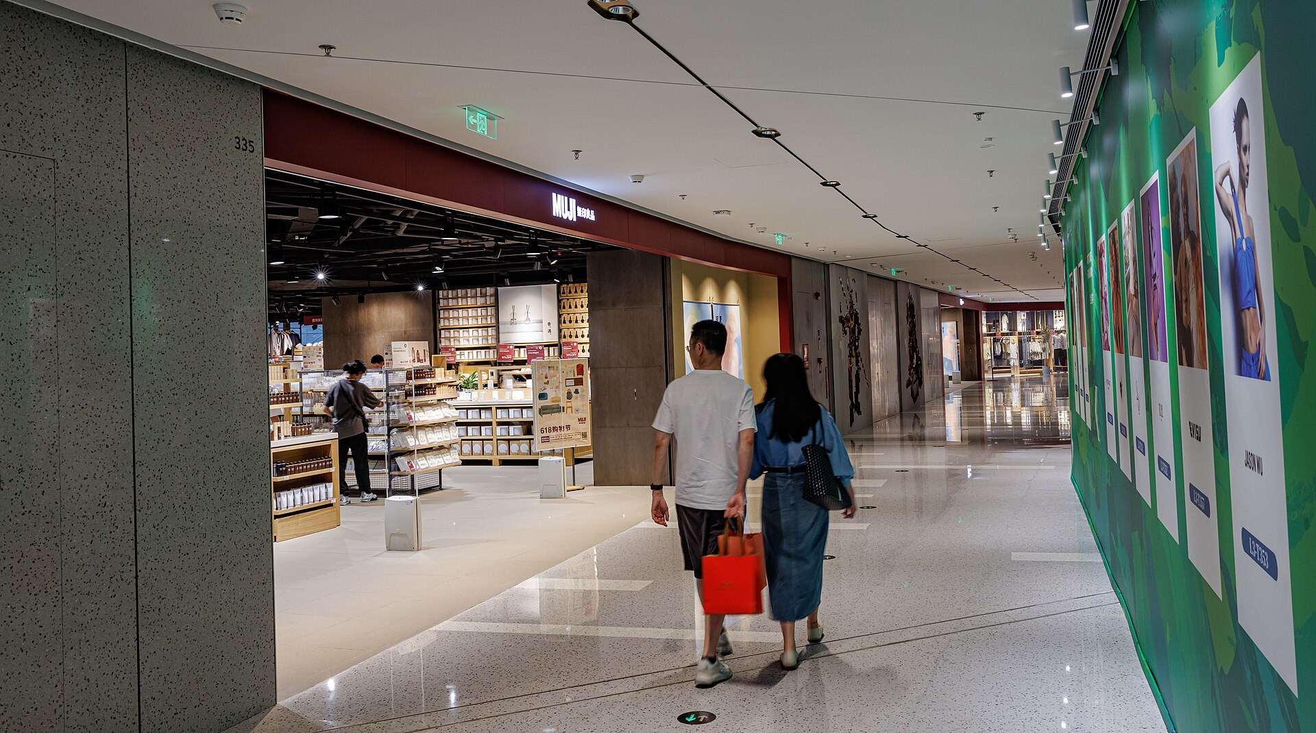 多個無印良品行李箱整齊排喺地上,酒紅、米色、黑色,背景係乾淨嘅商店環境,無文字無 Logo
