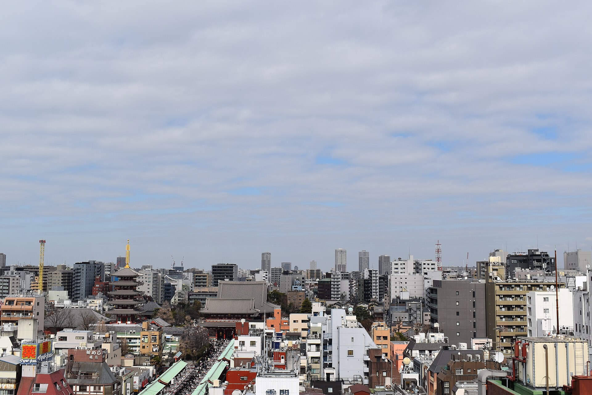 東京淺草街區，現代商業大樓同傳統日式建築並存，秋日多雲天光