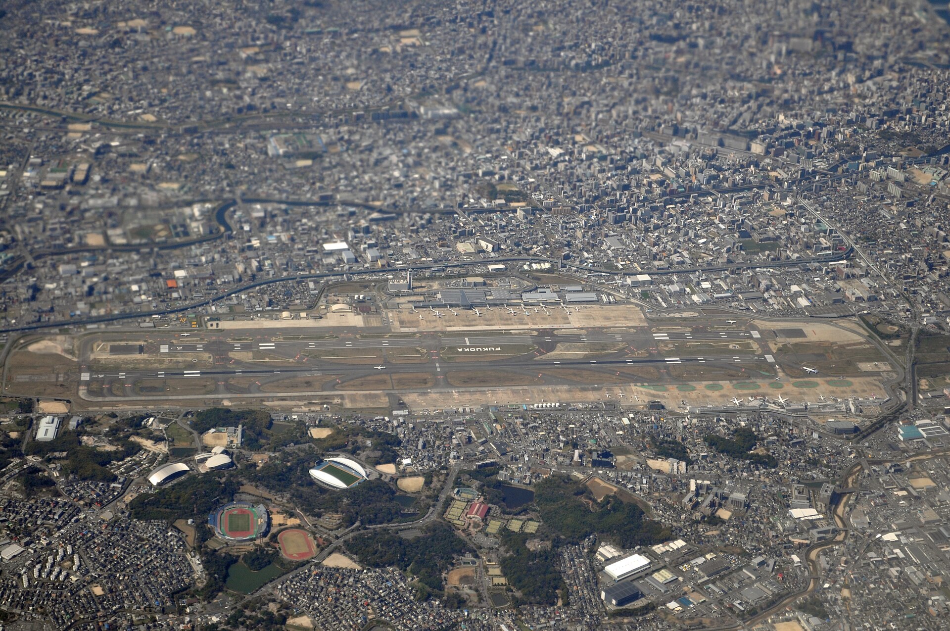 黑色竹炭 original cone 載住軟冰淇淋，後方為日本風插畫壁畫，位於福岡機場國際線 terminal