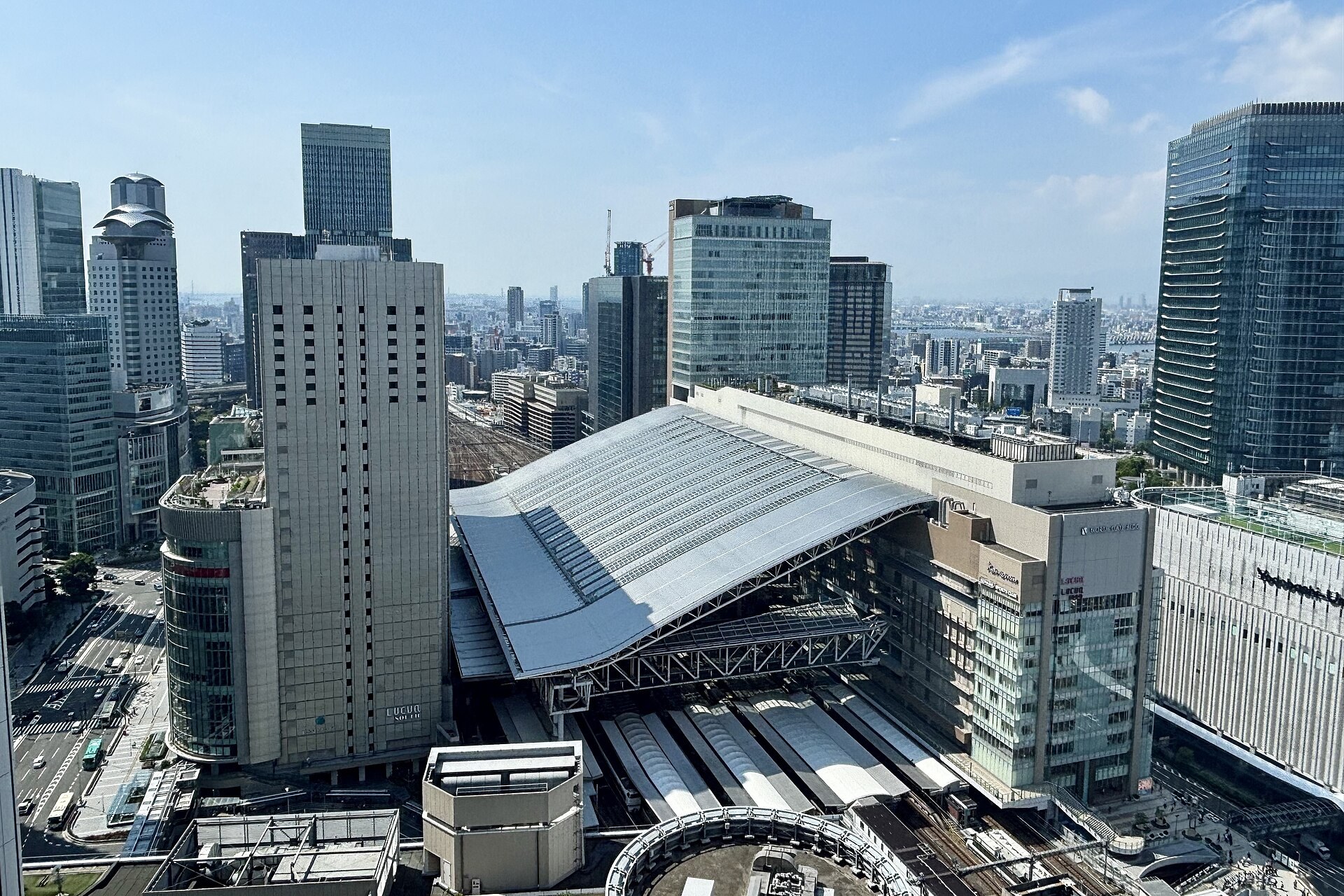 大阪站高速巴斯塔內停泊嘅長途高速巴士，旅客喺月台等候
