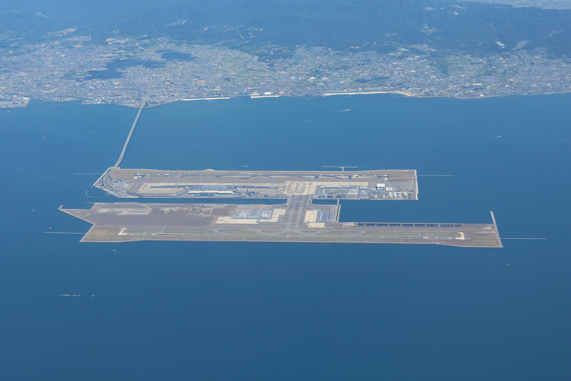 一架長程客機喺跑道上起飛,背景係遠山與城市輪廓