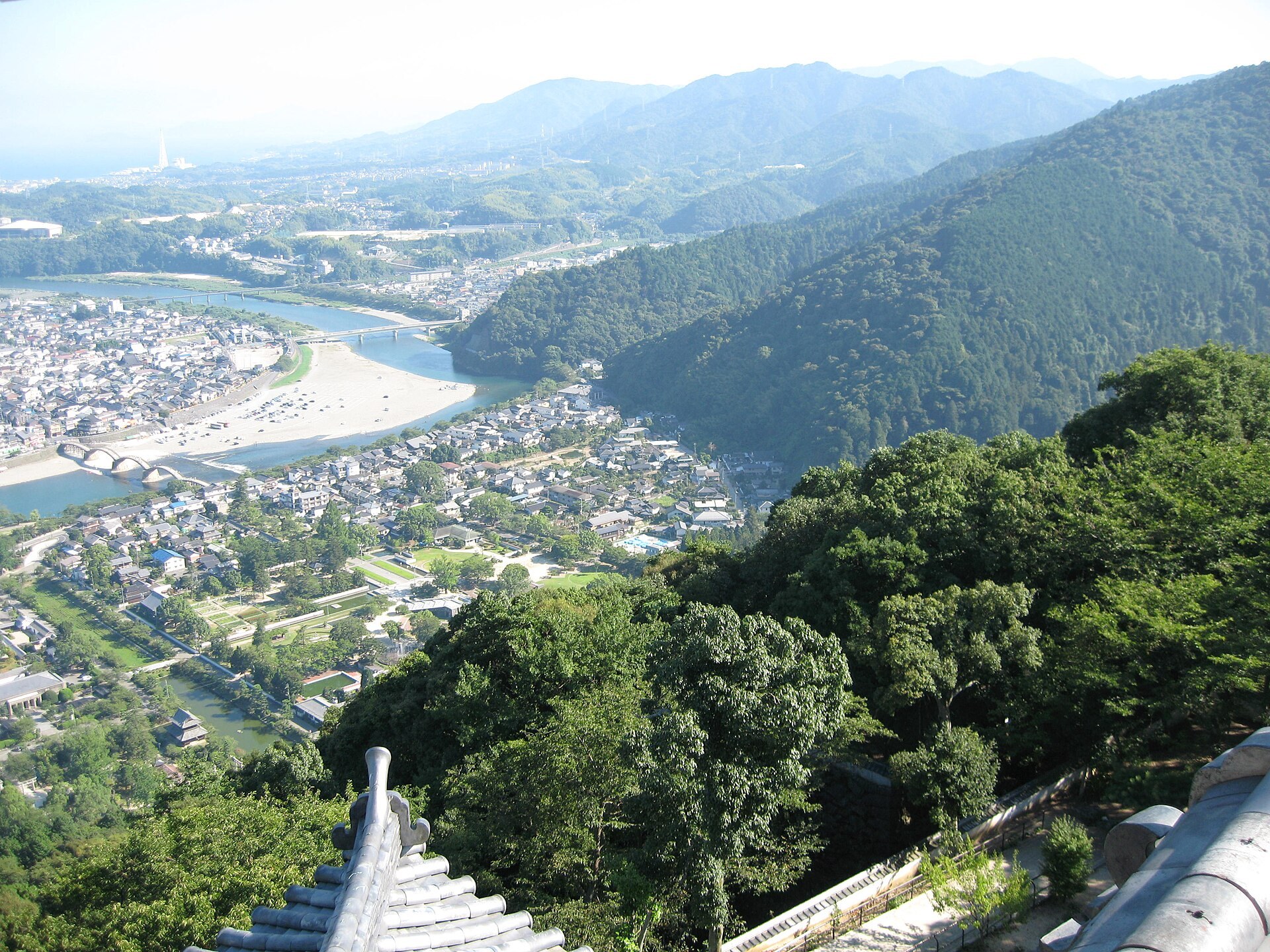 日本山口縣戶外實景謎解謎活動，市民喺歷史建築前查閱手冊解謎，周圍係公園同商店街。