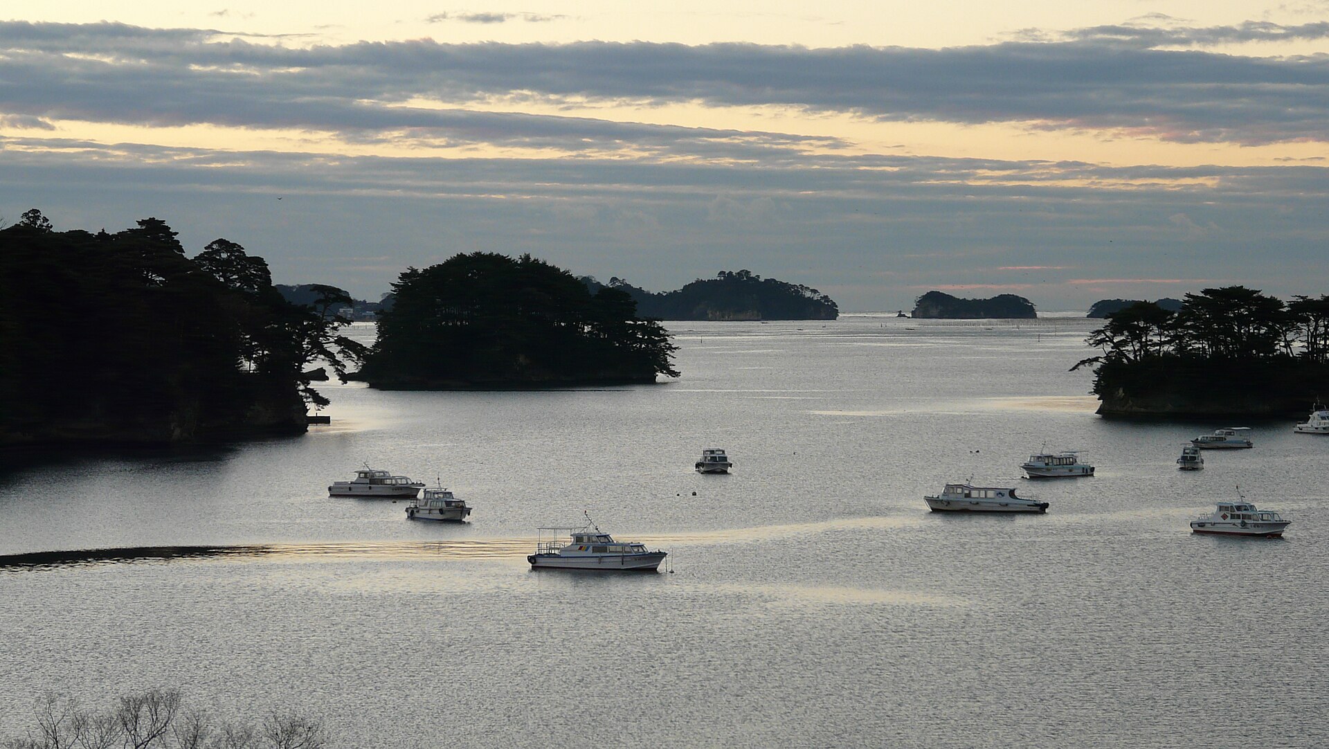 一輛汽車停泊喺日本嘅指定車中泊設施，背景為松島及海灣景色