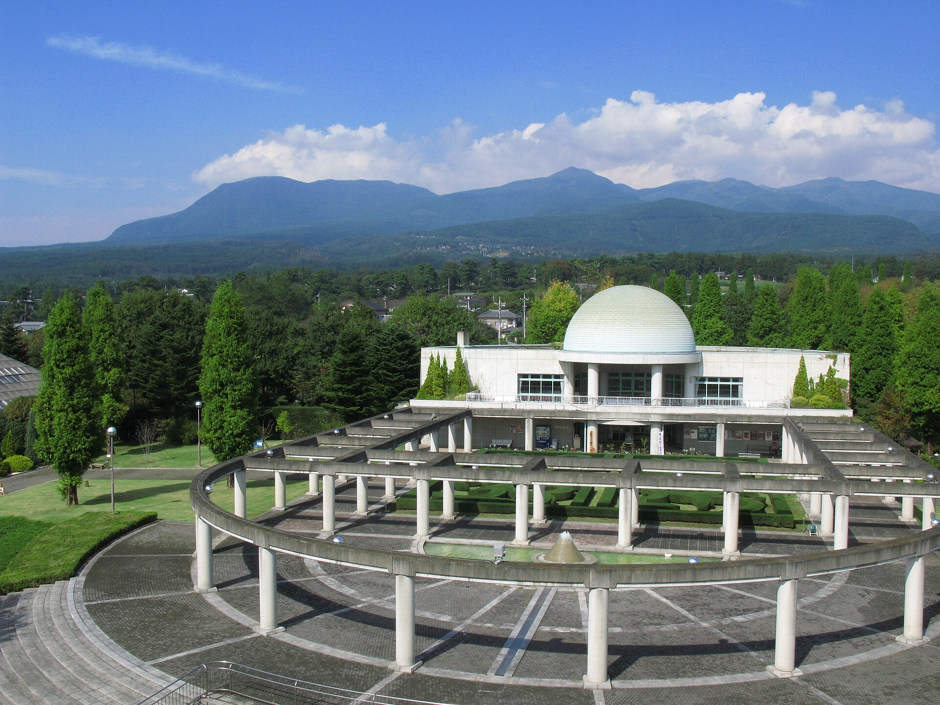 群馬花卉公園主花園嘅起伏花地,四季花卉同遊客行入花園嘅場景(圖為示意)