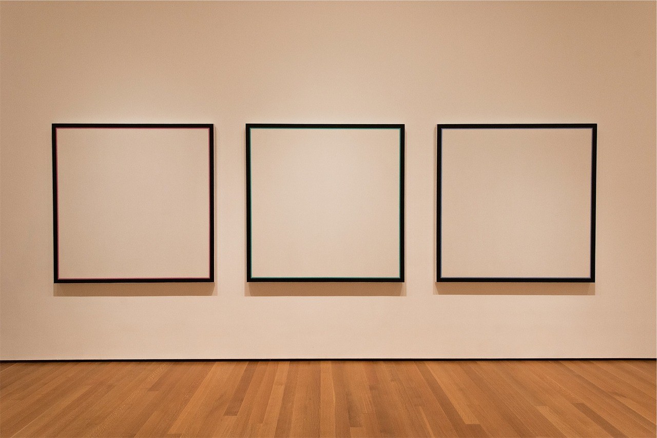 展覽gallery內部一隅：白牆懸掛當代藝術作品，幾位訪客喺作品前駐足欣賞
