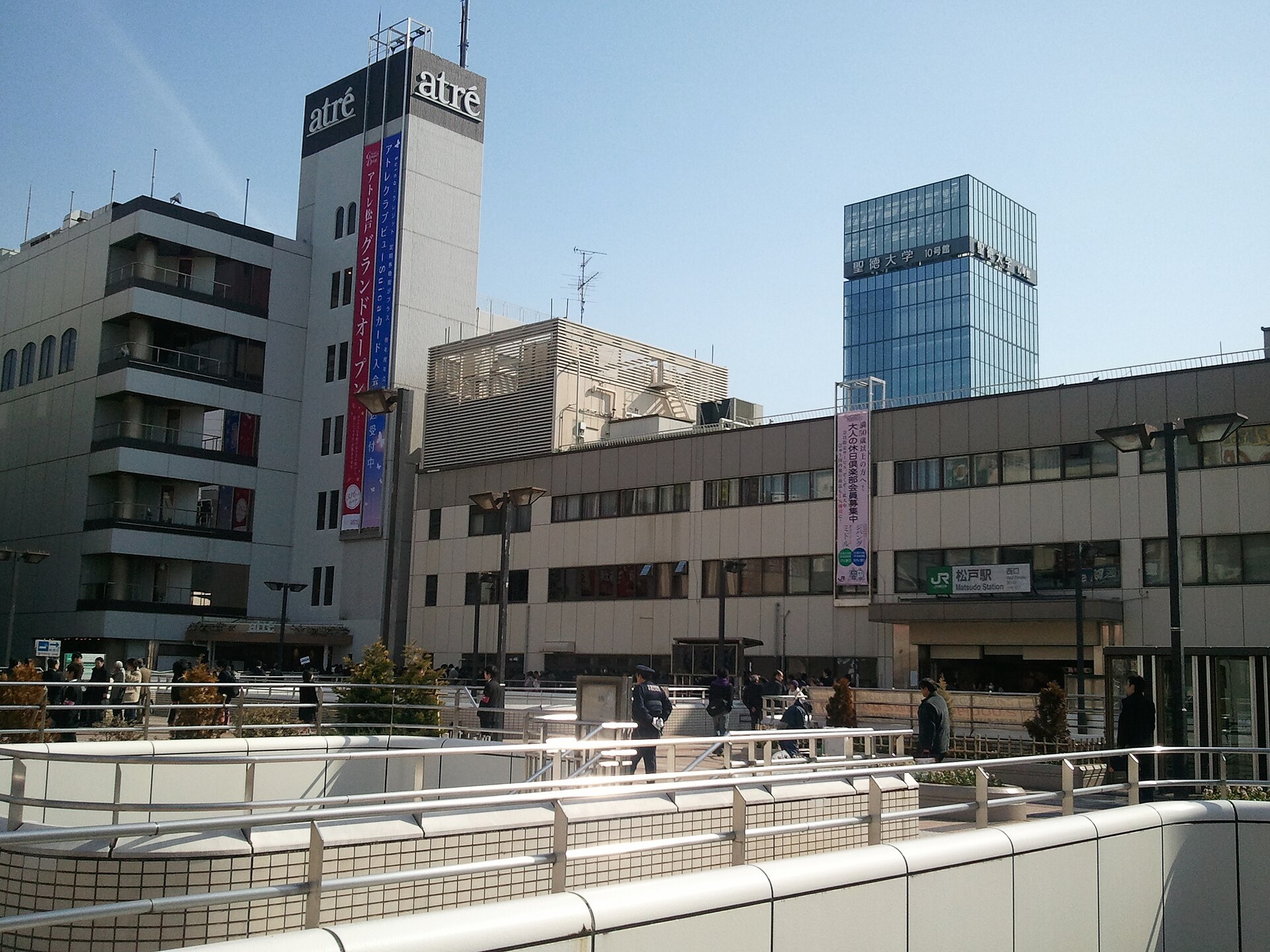 松戸商業設施內，遊客服從背景／遠處，手持地圖同提示冊行經，無清晰面部。