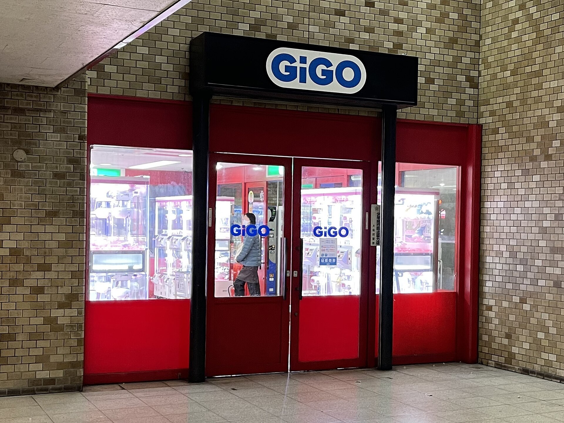 日本電玩城（GiGO 式）嘅抓娃娃機（クレーンゲーム）陳列，玻璃櫃內擺滿小公仔景品。